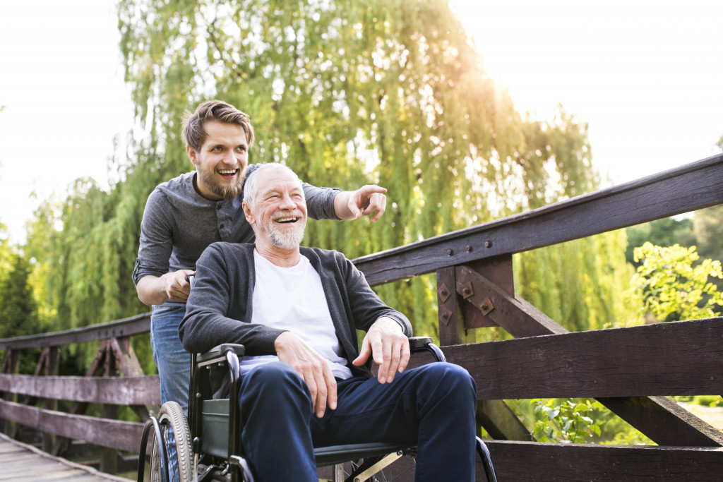 grandson bonding his grandfather on a wheelchair