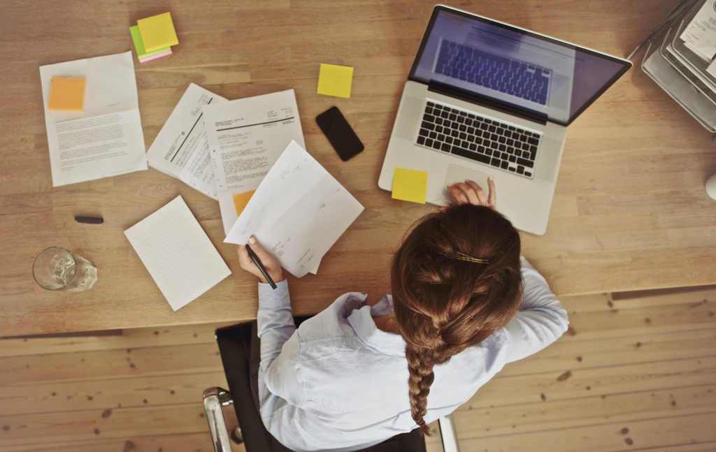woman busy in the office with desk cluttered with papers