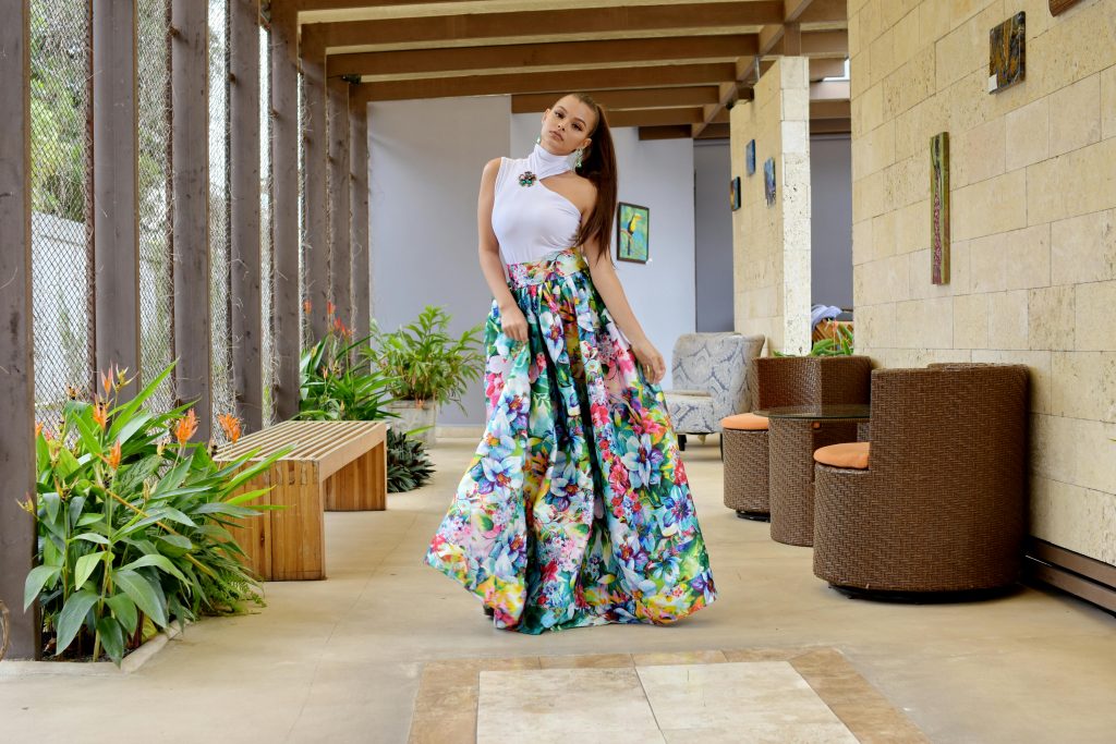woman wearing a floral maxi dress and a white asymmetrical top