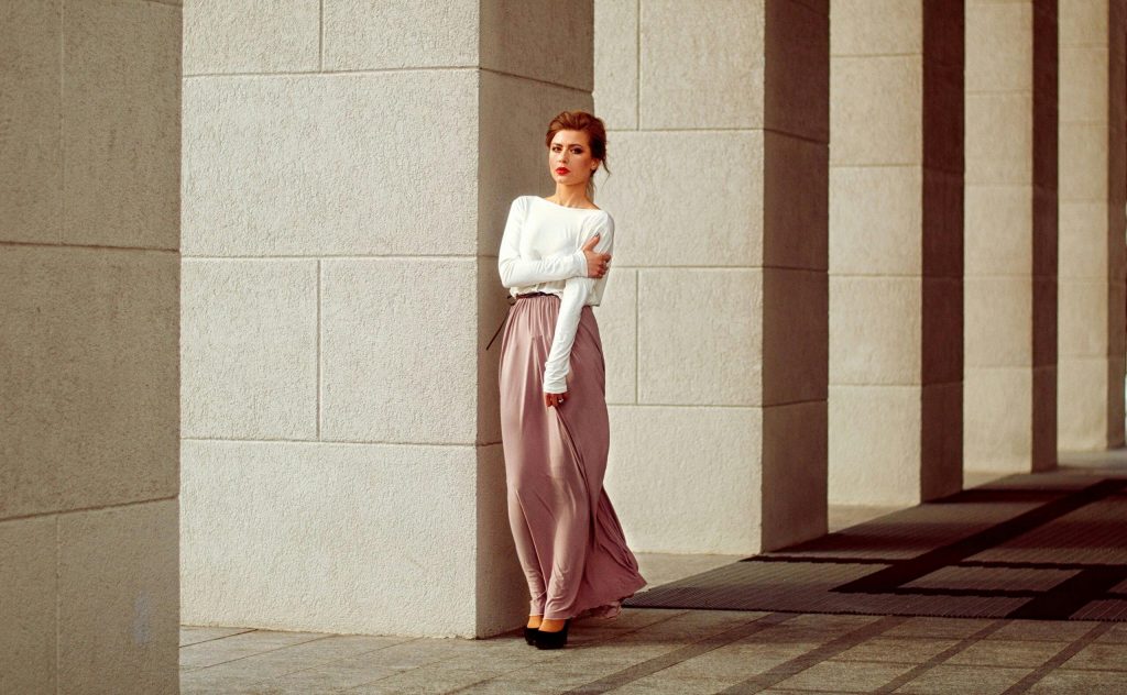 woman wearing a pink maxi skirt paired with a white long-sleeved top